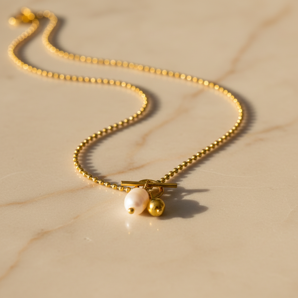 Gouden ball chain ketting met witte zoetwaterparel en toggle sluiting